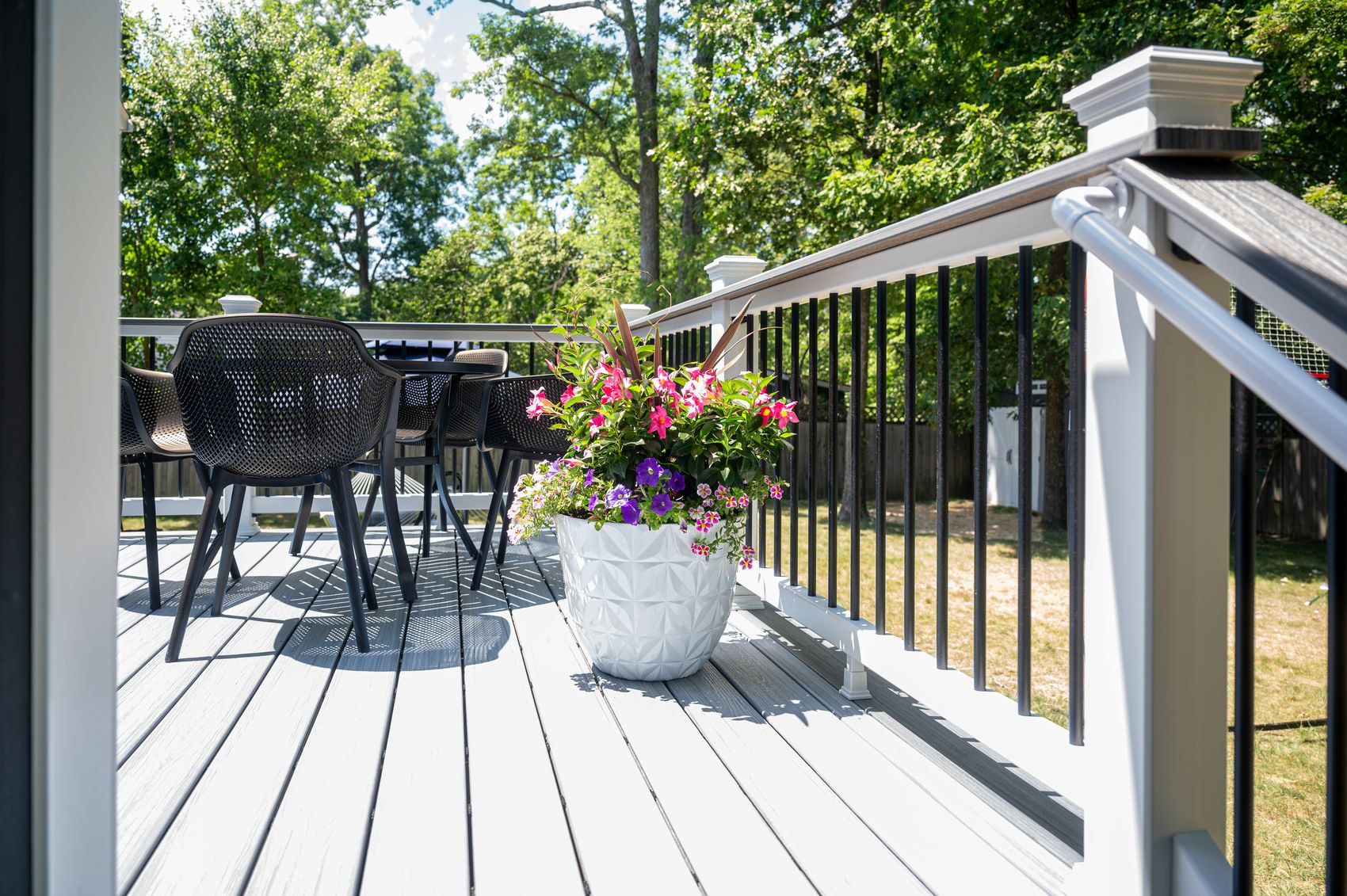 White posts with black aluminum balusters on a composite deck